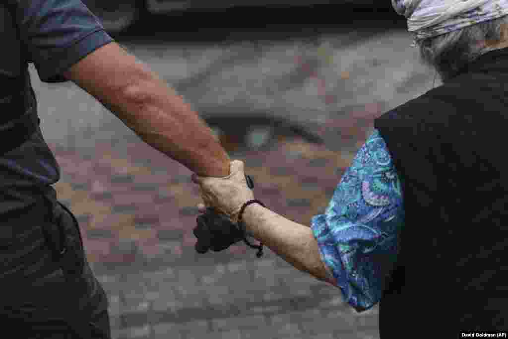 As Russian forces press into the region, authorities are hopeful that the mandatory evacuation order will bring out up to 220,000 people from the eastern province. One such evacuee is Valentyna Abramanovska, 87, who is taking only a black-and-white photograph of her mother and sister taken nearly 50 years ago on the Sea of Azov, a memento of her life to carry with her as she is led by a volunteer to a van.