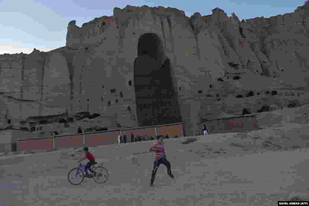 Afghan children play in the shadow of where a Bamiyan Buddha statue once stood before it was destroyed by the Taliban in March 2001.