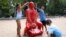 Câțiva copii aruncă cu nisip pe o statuie a președintelui rus Vladimir Putin, călare pe un tanc, în Central Park, 2 august 2022. Creația îi aparține artistului francez James Colomina.