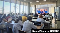 Kournalists watch a speech by Kazakh President Qasym-Zhomart Tokayev at the Kazmedia press center in Nur-Sultan in July 2022. 