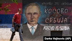 Muškarac prolazi pored grafita koji prikazuje ruskog predsednika Vladimira Putina i na kojem piše "Kosovo je Srbija" u Beogradu, 1. avgust 2022.