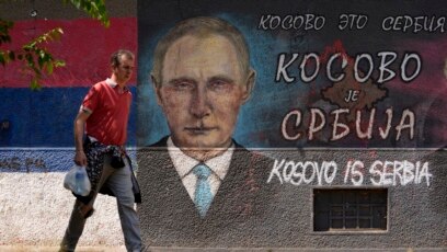 Muškarac prolazi pored grafita koji prikazuje ruskog predsednika Vladimira Putina i na kojem piše "Kosovo je Srbija" u Beogradu, 1. avgust 2022.