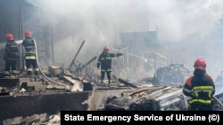 На этом фото, предоставленном Службой по чрезвычайным ситуациям Украины, пожарные тушат пожар в здании, поврежденном в результате обстрела, в Виннице, Украина, в четверг, 14 июля 2022 года. 