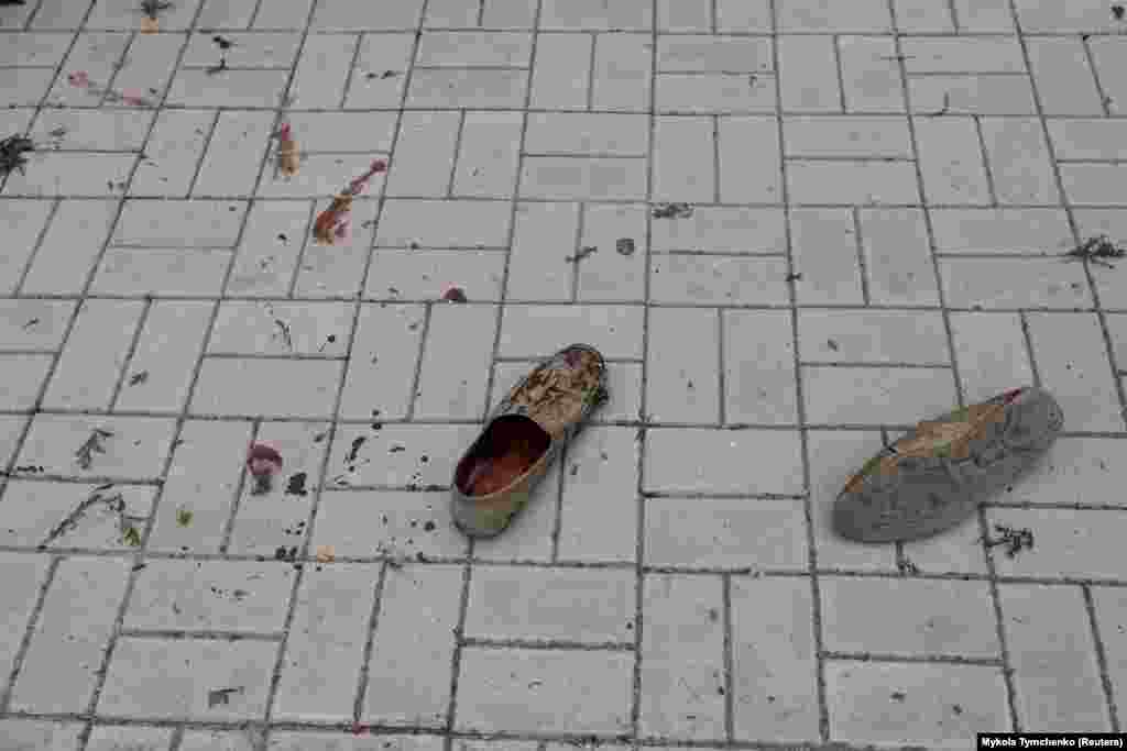 The shoes and blood of a person killed during a Russian military strike are seen on a street in Mykolayiv, Ukraine.