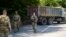Militari americani din KFOR patrulând lângă un camion sârbesc care bloca șoseaua în apropiere de Zubin Potok, 1 august 2022.