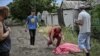 Мужчына кідаецца да цела сына, які загінуў падчас абстрэлу касэтнымі бомбамі гораду Лісічанску. 18 чэрвеня 2022