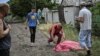A father approaches the body of his son who was reportedly killed by a Russian cluster rocket in the city of Lysychansk in eastern Ukraine on June 18.