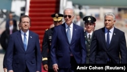 Kryeministri izraelit Yair Lapid dhe Presidenti Isaac Herzog mirëpresin Presidentin e SHBA-së Joe Biden në Aeroportin Ndërkombëtar Ben Gurion pranë Tel Avivit më 13 korrik.