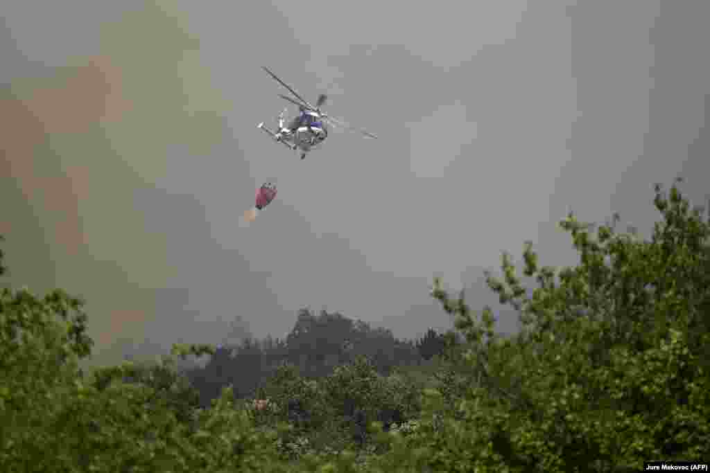 Një helikopter i policisë sllovene duke dërguar ujë për fikjen e zjarrit, në fshatin Lipe, Slloveni, më 22 korrik.