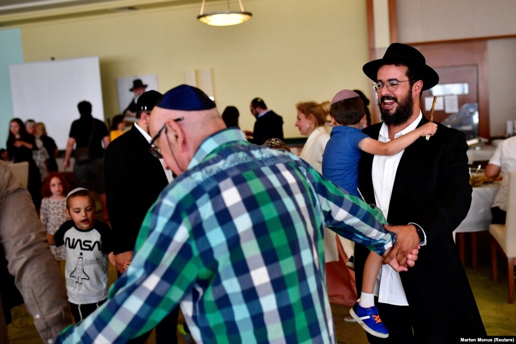 Refugjatët hebrenj hasidikë duke vallëzuar gjatë një feste fetare në fshatin humanitar Machne Chabad në Balatonoszod, Hungari, më 11 korrik. &nbsp;
