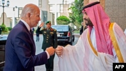 Снимка, публикувана от саудитския кралски дворец на 15 юли 2022 г., показва саудитския престолонаследник принц Мохамед бин Салман да се поздравява с юмруци с президента на САЩ Джо Байдън в двореца Ал-Салам в Джеда.