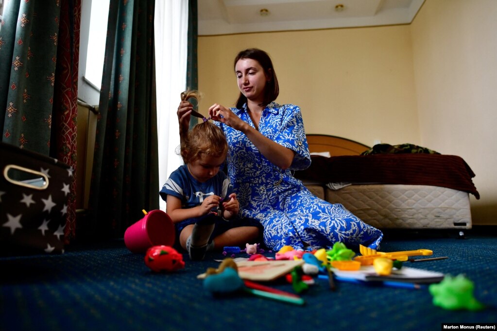 Neomi Gluzman Kravchenko, një refugjate hebreje hasidike nga Ukraina, duke luajtur me djalin e saj, Mykhaylo, në dhomën e tyre. Derisa disa kanë hequr dorë nga ideja e kthimit në Ukrainë, Kravchenko thotë se shpreson që ata të mund ta presin fundin e luftës duke qëndruar në Hungari dhe më pas të shkojnë në shtëpi.