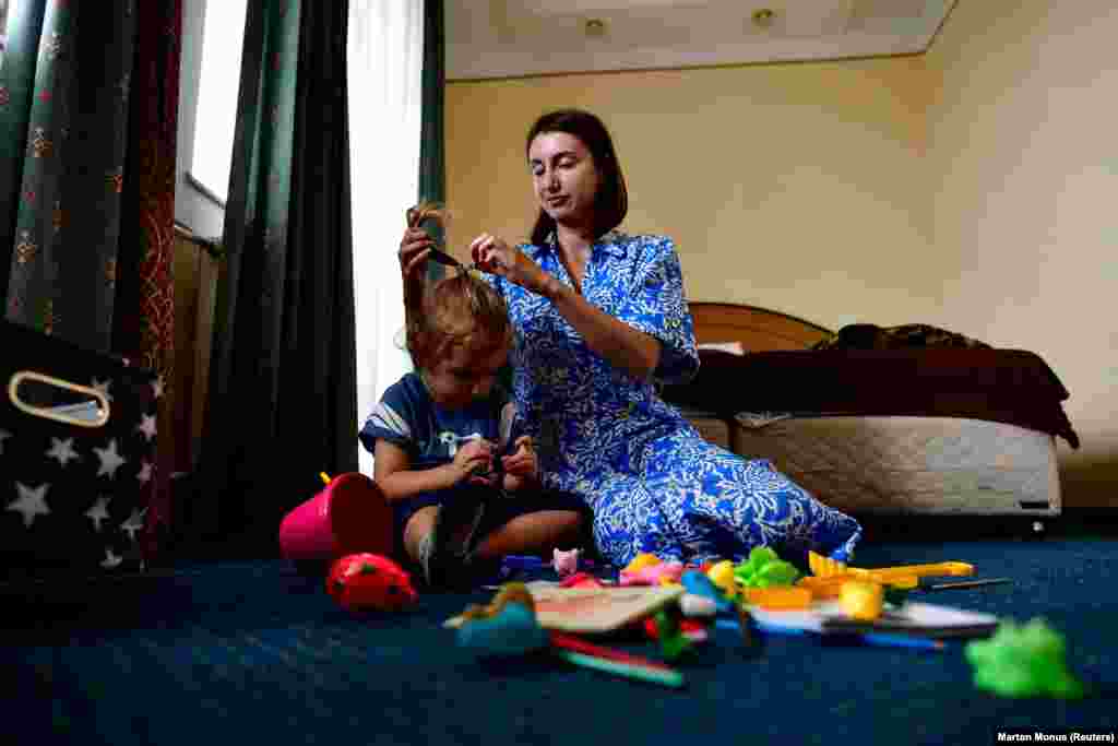 Neomi Gluzman Kravchenko, a Hasidic Jewish refugee from Ukraine, plays with her son Mykhaylo in their room. While some have given up on the idea of returning to Ukraine, Kravchenko says she hopes they can wait out the war in Hungary and then go home.