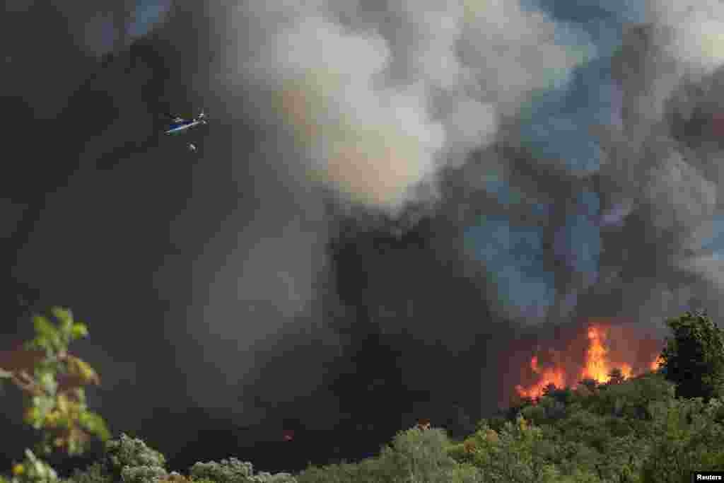 Helikopter u oblacima dima pri gašenju požara u blizini slovenske granice kod mjesta&nbsp;Rupa, 20. juli 2022.