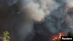 Helikopter u oblacima dima pri gašenju požara u blizini slovenske granice kod mjesta Rupa, 20. juli 2022.