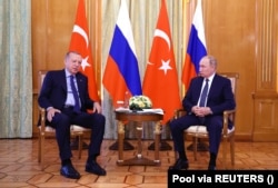 Владимир Путин слушает президента Турции Реджепа Эрдогана во время встречи в Сочи, Россия, 5 августа 2022 года