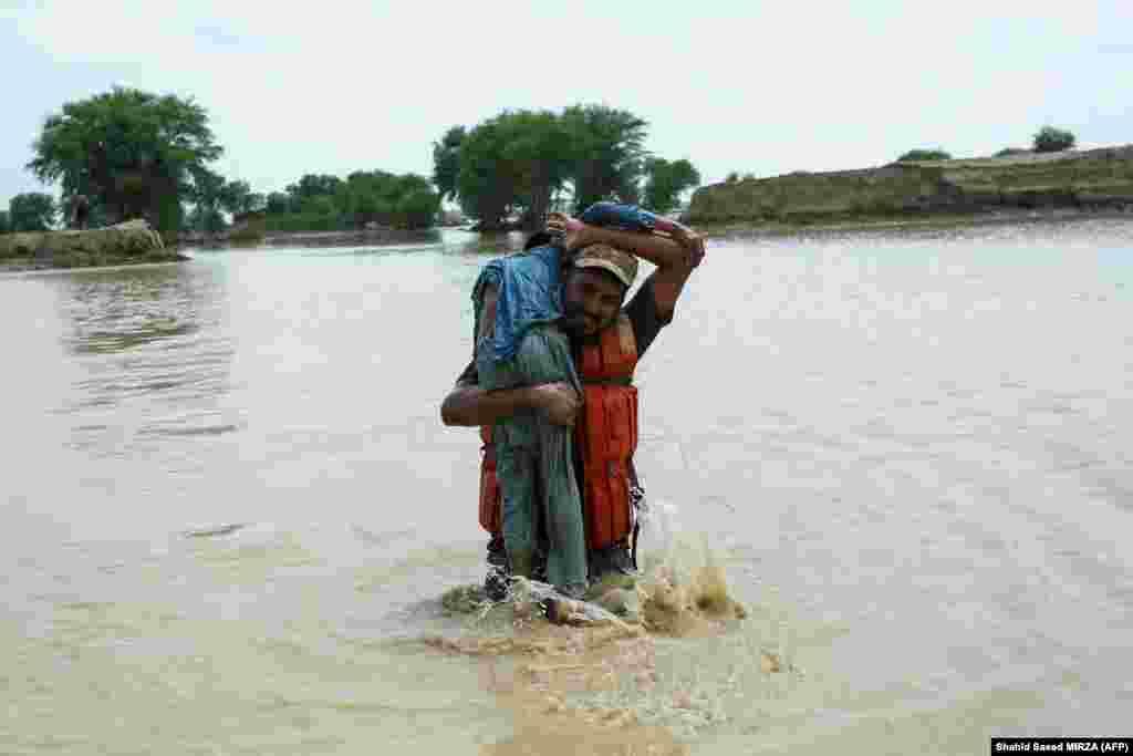 A Pakistani soldier rescues a child from the flood-affected Rajanpur district in Punjab Province.&nbsp;