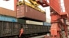 A worker in Lianyungang in China's Jiangsu Province climbs out of a freight train bound for Kazakhstan as a container is loaded onto the vehicle. (file photo) 