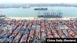 An aerial view shows containers and cargo vessels at the Qingdao port in China’s Shandong Province in May. 