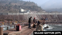 Китайський інженер керує робітниками, які будують міст через річку в Пакистані
