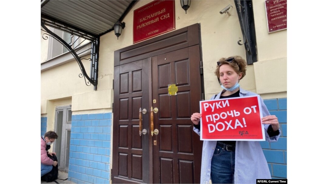 A single protester, as allowed by law, demands "hands off Doxa" outside the court in Moscow.