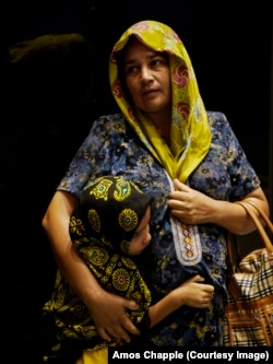 A woman shelters from the same rainstorm with her daughter.