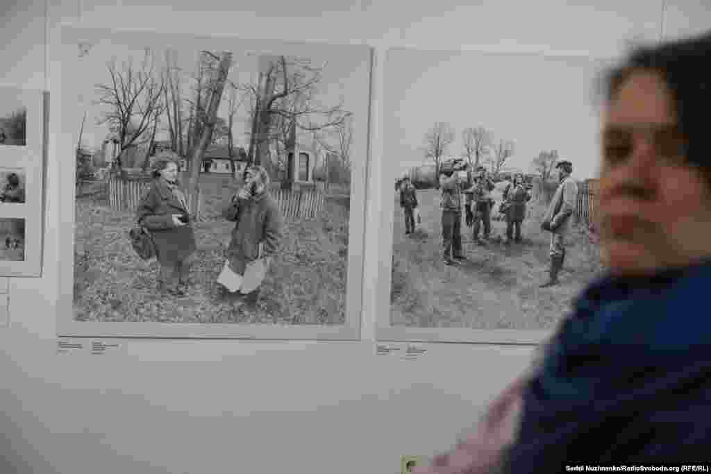 Відвідувачка виставки на тлі фотографій Ліни Костенко у Чорнобильській зоні