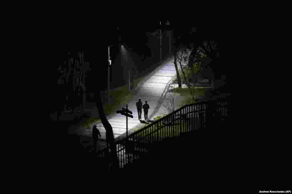 People walk in a park during a blackout in Kyiv.