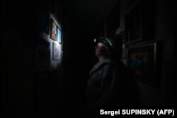 A man wears a headlamp during a power cut in his building in the north of Kyiv.