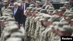 German President Frank-Walter Steinmeier walks past troops as he visits a US Army training camp based in his country.