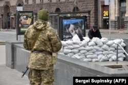 Волонтер укладывает защитные мешки с песком у входа в метро в центре Киева, 7 марта 2022 г.