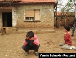 Ethnic Albanian children cry outside the house where two young parents were killed, along with another woman, when a Serbian mortar slammed into the courtyard of their family compound in Kosovo on May 3, 1998.