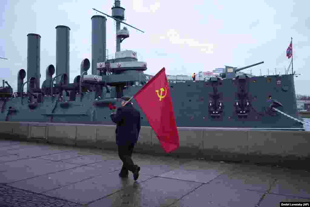 A Communist Party supporter walks past the cruiser Aurora on the 105th anniversary of the 1917 Bolshevik Revolution in St. Petersburg, Russia, on November 7.