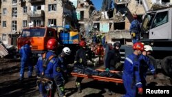 Echipele de salvatori intervin la o clădire care a fost lovită de una dintre bombele rusești. 