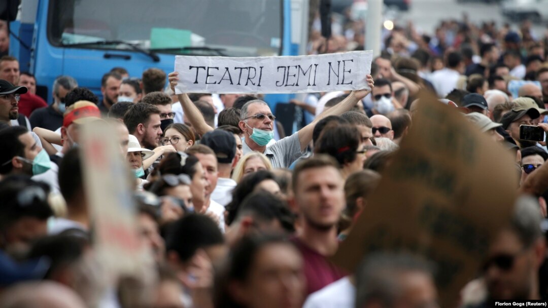 Demonstrant nosi transparent na kojem piše "Mi smo pozorište" na protestu u Tirani u ponedeljak, 18. maja
