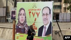 Предвыборный плакат партии премьер-министра Нури аль-Малики с его изображением (справа) в Багдаде. 