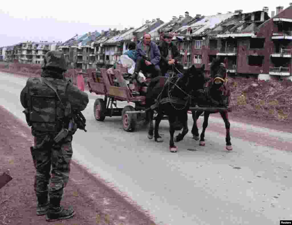 Konjska zaprega sa ličnim stvarima bosanskih Srba prolazi pored vojnika francuskog IFOR-a na izlasku iz Sarajeva na putu prema teritoriji Republike Srpske, 30. januar 1996.&nbsp;