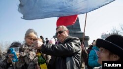 People in Sevastopol crack open some champagne upon watching a televised speech by Russian President Vladimir Putin after which he signed a treaty approving the annexation of Crimea on March 18. 
