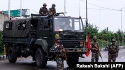 Security personnel stand guard on a street in Jammu on August 5.