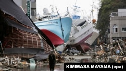 In this file picture from April 28, 2011, fishing vessels are shown washed ashore, amid the fire-ravaged Shishiori district of the port city of Kesennuma, weeks after a devastating tsunami hit Japan. 