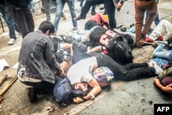 Стамбул, 31 мая 2014 года, протестующие против застройки парка Гези лежат на земле, спасаясь от слезоточивого газа, который полиция распыляет для их разгона