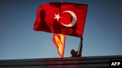 Turkey -- A man waves his national flag on Taksim square in Istanbul, 09Jun2013