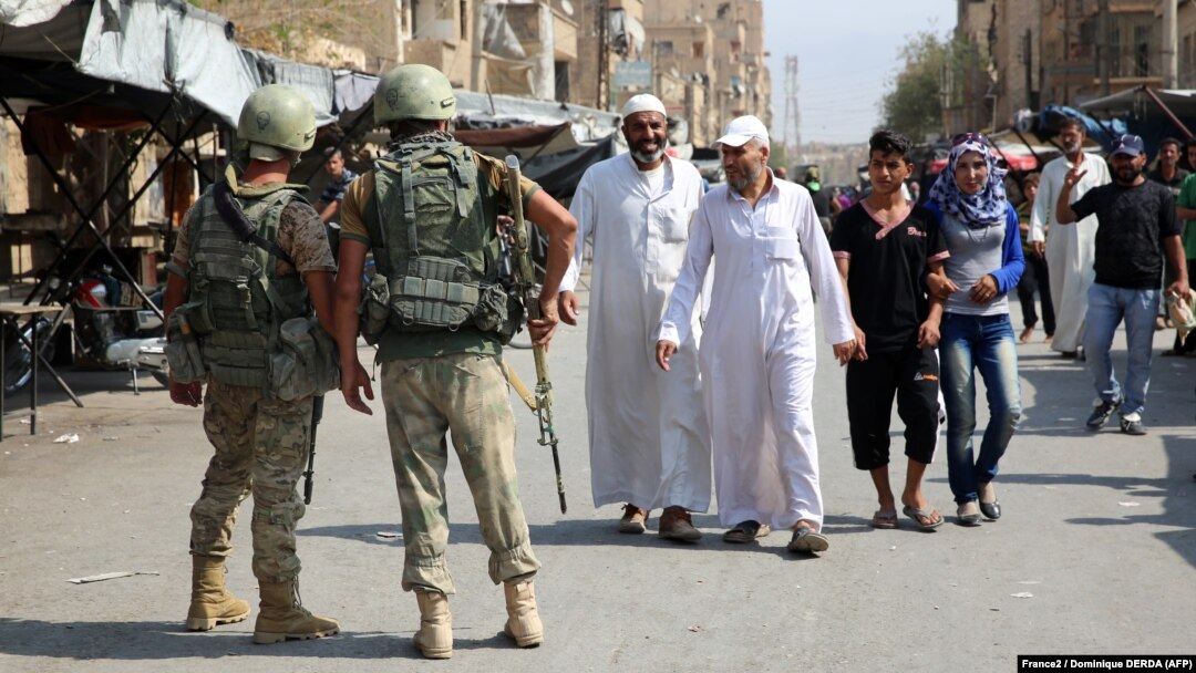 Russian soldiers stand guard in a central street in the eastern Syrian city of Deir al-Zor in September 2017.