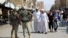 Russian soldiers stand guard on a central street in Syria's eastern city of Deir al-Zor as locals pass by earlier this month.