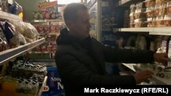 Yuriy Filimonov stocks a dairy shelf amid a rolling blackout on November 6 in Kyiv.