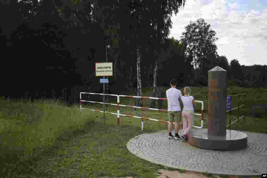 Un cuplu în locul unde se întâlnesc granițele Poloniei, Lituaniei și Kaliningradului rusesc, în Zerdziny, Polonia, în luna iulie. Frontiera Kaliningradului cu Polonia a fost una dintre ultimele porțiuni de teren de la periferia UE care nu avea o barieră fizică.