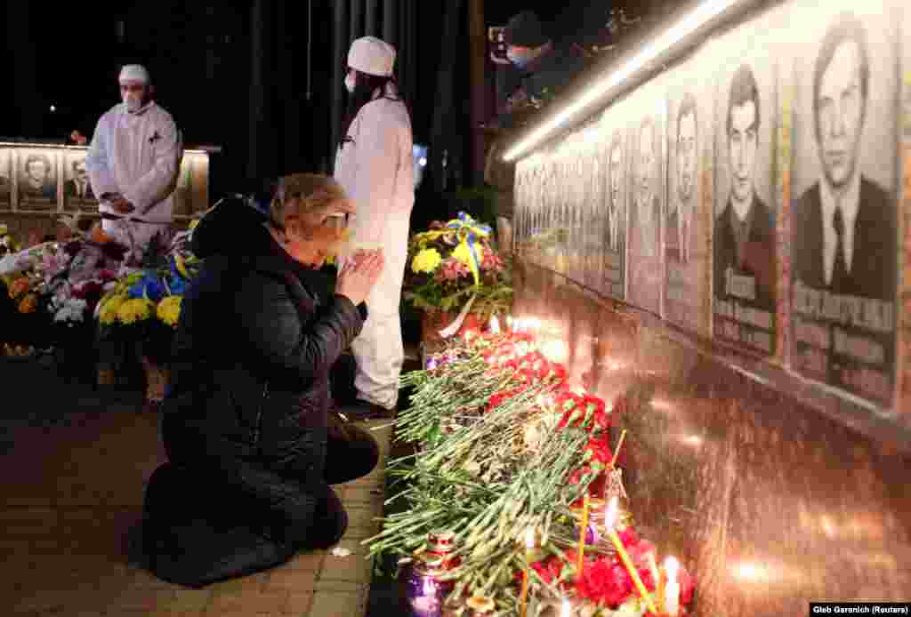 Жена се моли на спомен-обележјето во Славутич посветено на пожарникарите и работниците кои загинаа во нуклеарната катастрофа во Чернобил.