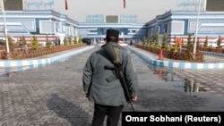 An Afghan policeman stands guard outside the hall where the attack happened in Kabul on November 21.