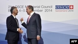 Switzerland -- Swiss President and OSCE Chairperson-in-office Didier Burkhalter (L) welcomes Russian Foreign Minister Sergei Lavrov at the opening of an OSCE ministerial meeting in Basel, December 4, 2014