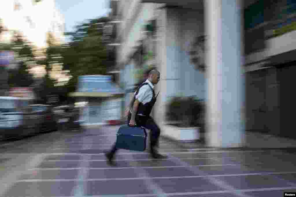 A security worker brings money to a National Bank branch in Athens, Greece, on June 29. Greece's European partners shut the door on extending a credit lifeline to Athens, leaving the country facing a default that could push it out of the euro and cause ripple effects across the European economy and beyond. (Reuters/Marko Djurica)